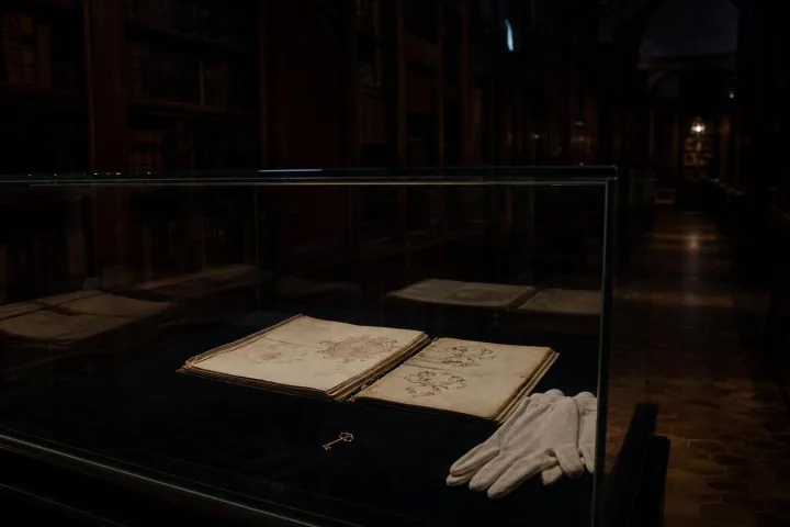 Manoscritto vittoriano esposto in una teca buia con una piccola chiave riflessa nel vetro