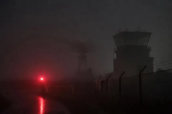 Una pista militare immersa nella nebbia davanti a un radar spento