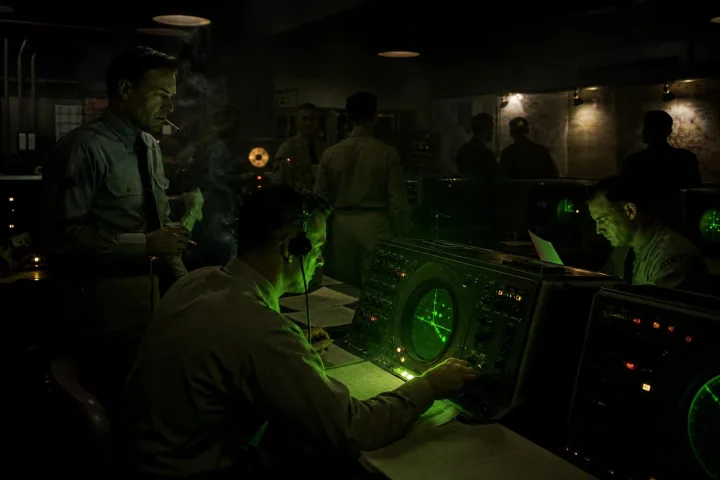 Schermi radar illuminati in una sala operativa notturna durante un controllo militare del 1956